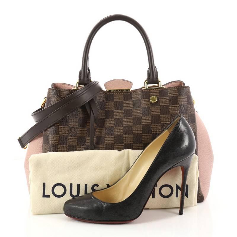This authentic Louis Vuitton Brittany Handbag Damier from 2018 makes an elegant statement. Crafted from damier ebene coated canvas and pink cuir taurillon leather, this sophisticated bag features dual-rolled leather handles, smooth brown cowhide