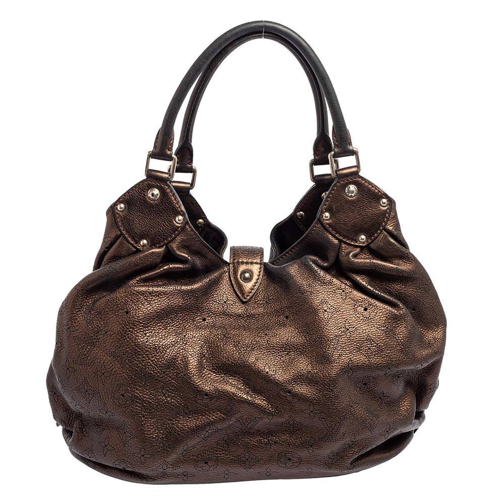 This beautifully stitched Mahina leather bag is by Louis Vuitton. With a capacious Alcantara-lined interior, comfortable handles, and a fine finish, this slouchy bronze-colored hobo is bound to offer style and practical ease.

Includes: Original