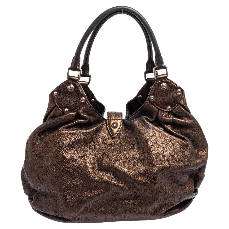 Diese wunderschön genähte Mahina Ledertasche ist von Louis Vuitton. Mit ihrem geräumigen, mit Alcantara gefütterten Innenraum, den bequemen Griffen und der edlen Verarbeitung ist diese schlanke, bronzefarbene Hobo stilvoll und praktisch