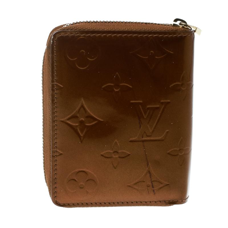 This Louis Vuitton Zippy coin wallet is conveniently designed for everyday use. Crafted from shiny bronze monogram Vernis patent leather, the wallet has a zip closure which opens to leather-lined compartments, multiple slots, and a flap pouch, for