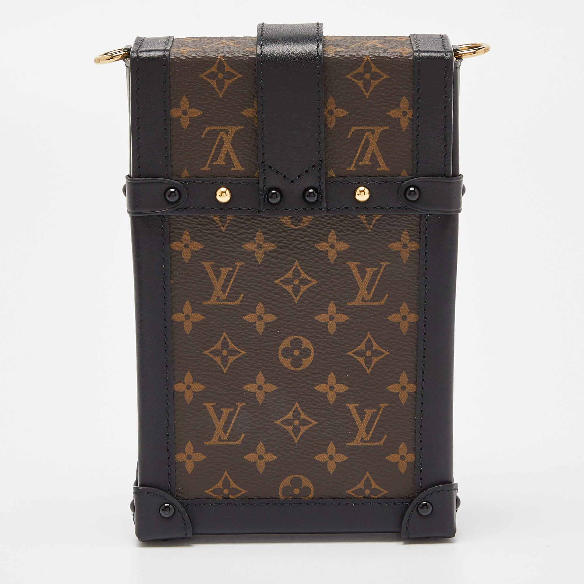 Die vertikale Tasche Pochette Trunk von Louis Vuitton ist aus Monogram Canvas und Leder gefertigt. Sie wird durch goldfarbene Beschläge ergänzt und von einem Schulterriemen gehalten.

