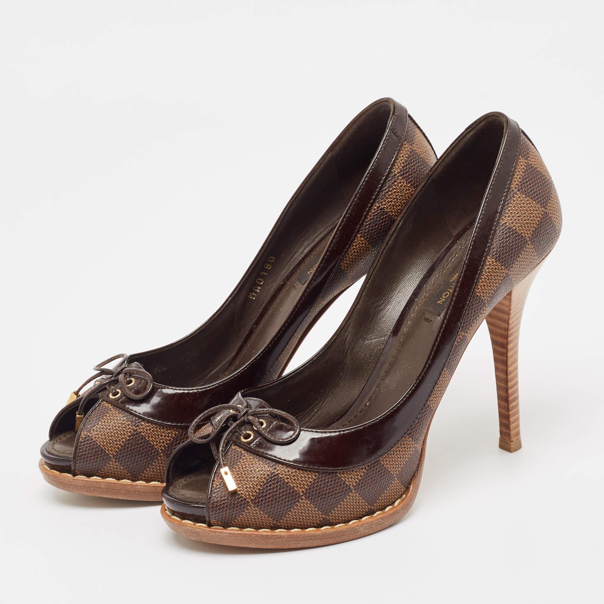 Feel the admiring glances coming your way whenever you step out in this pair of gorgeous pumps from Louis Vuitton. They are covered in Damier Ebene canvas as well as leather trims and designed with tie details peep toes and 12cm heels.