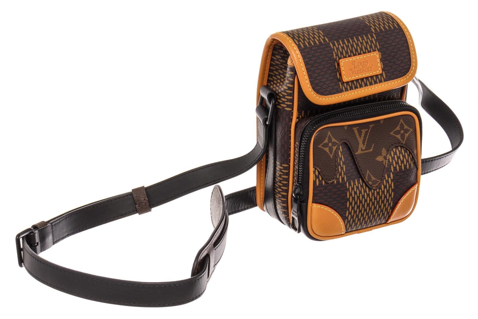 Louis Vuitton Nigo Amazone Nano Messenger Bag features giant Damier Ebene coated canvas and drip brown Monogram coated canvas at the front pocket, brown textile lining, cowhide leather trim, matte-black hardware, adjustable shoulder strap and flap
