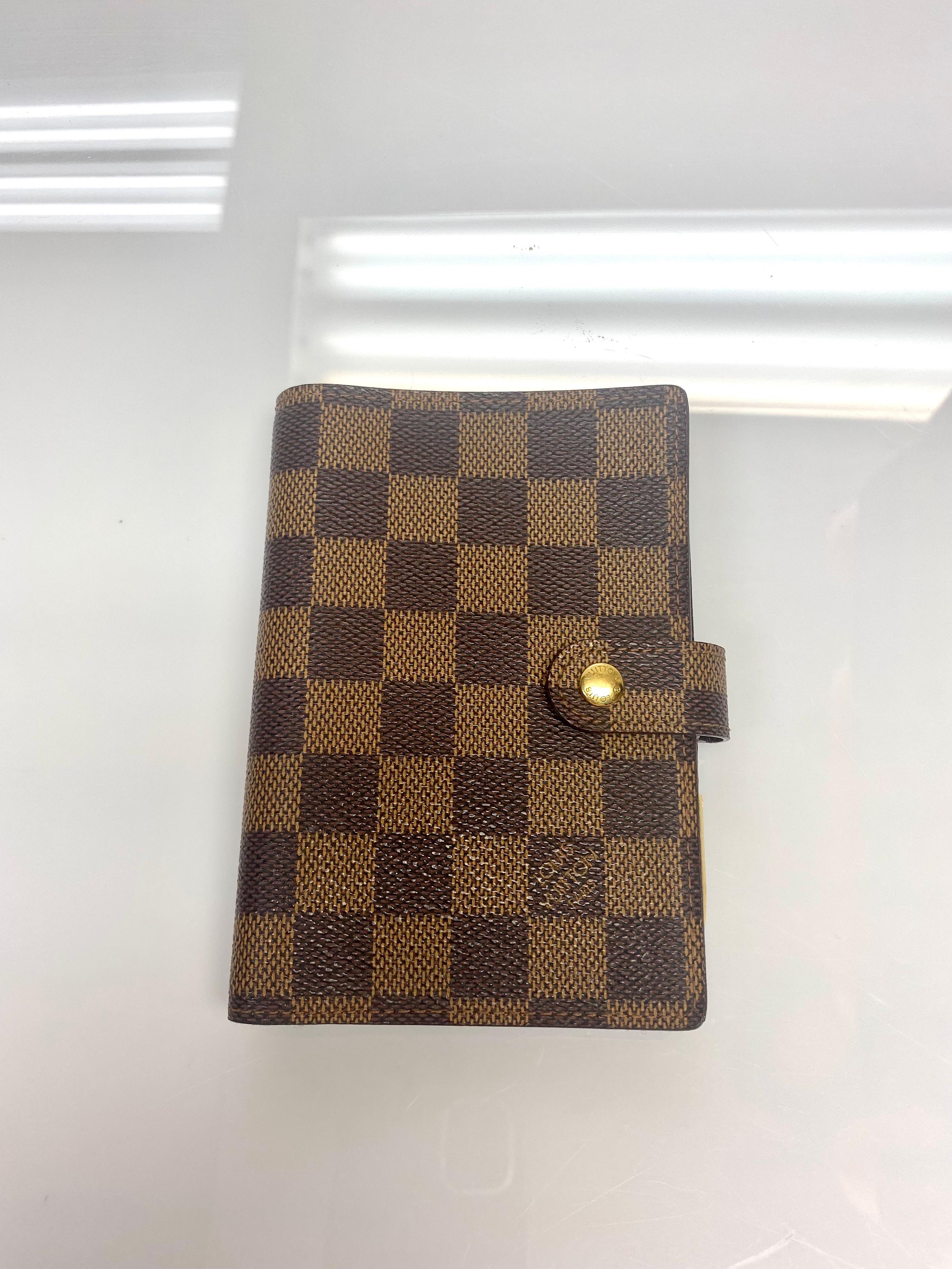 Louis Vuitton Brown Damier Print Agenda/Planner. Featuring the iconic Damier print in brown, gold hardware and accompanied by gold pen. Planner is for the year 2004. item is in excellent condition. 

Dimensions: 
W: 4