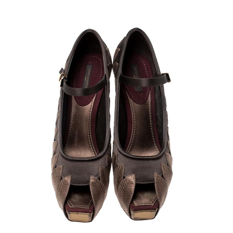 Exude elegance in an effortless way with these Mary Jane pumps by Louis Vuitton. They've been crafted from satin and carry a gorgeous brown hue with leaf appliques, peep toes and buckle fastenings. The pumps are balanced on high heels and completed