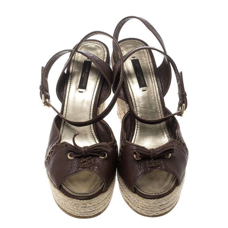 These girly and stylish Louis Vuitton sandals would complement your dresses, and casual separates perfectly. They are crafted from brown leather with beautifully adorned vamps featuring crisscross stitching and bows. They come with ankle straps