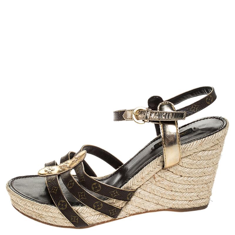 A perfect blend of comfort and style, these leather and Monogram coated canvas sandals come from the iconic house of Louis Vuitton. This espadrille pair is designed in an elegant shade of brown, features gold leather trims, 10.5 cm wedge heels and a