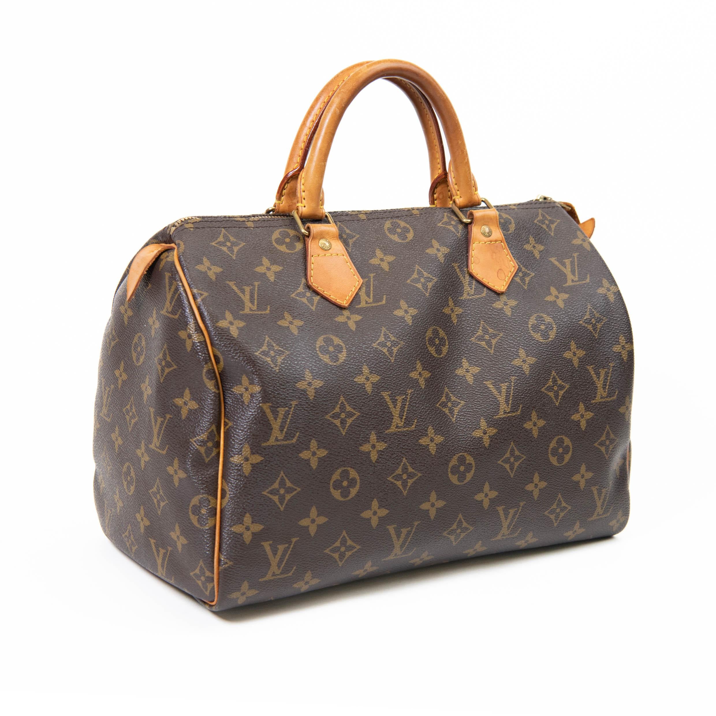 100% Authentic 

This classic handbag is finely crafted of traditional Louis Vuitton monogram coated canvas. The bag features vachetta cowhide leather trim and rolled top handles with polished brass hardware. The top zipper opens to a cocoa brown
