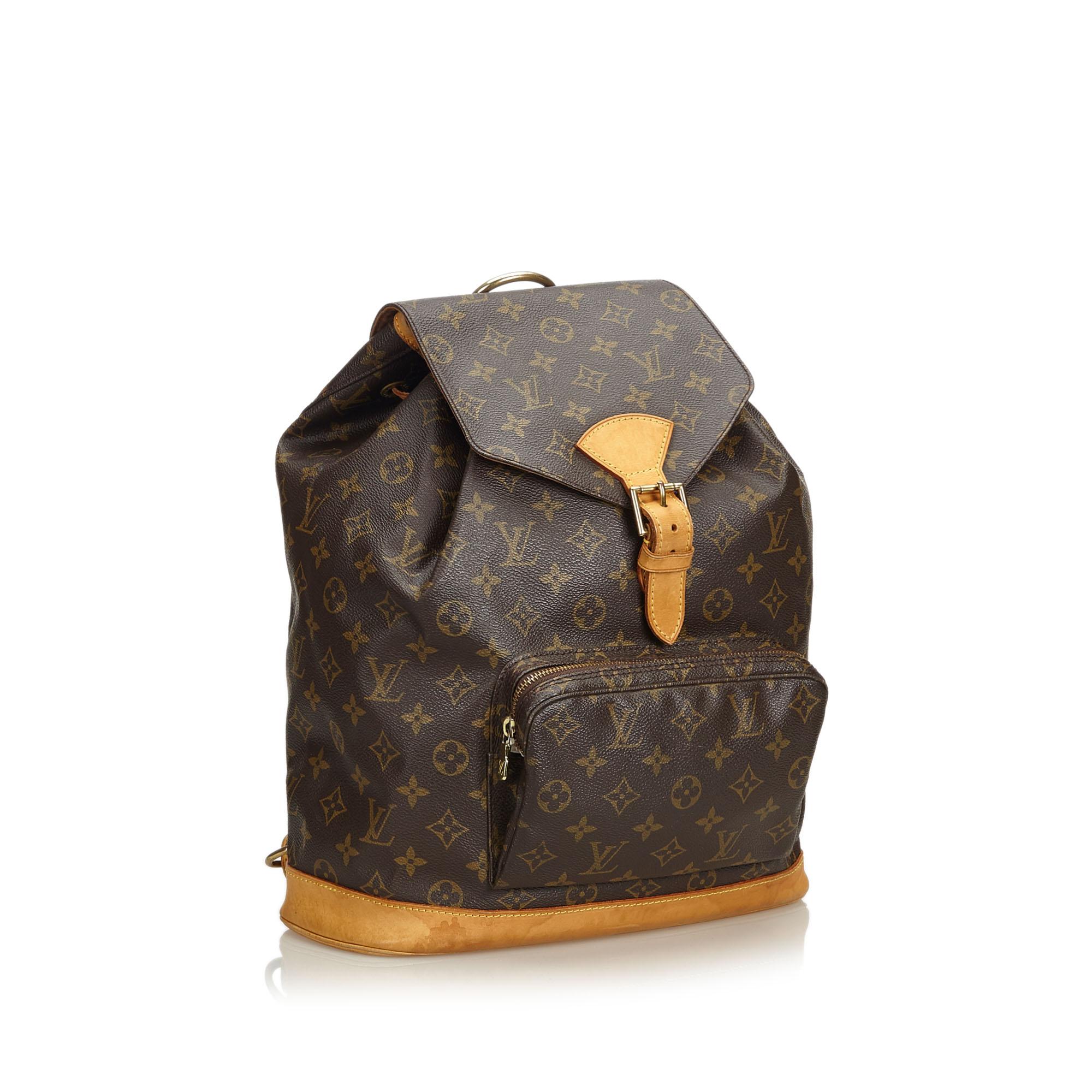 The Montsouris GM features a monogram canvas body, flat shoulder straps, a leather bottom, a front flap with a belt buckle detail and a magnetic closure, a top drawstring closure, and an interior slip pocket. It carries as B condition