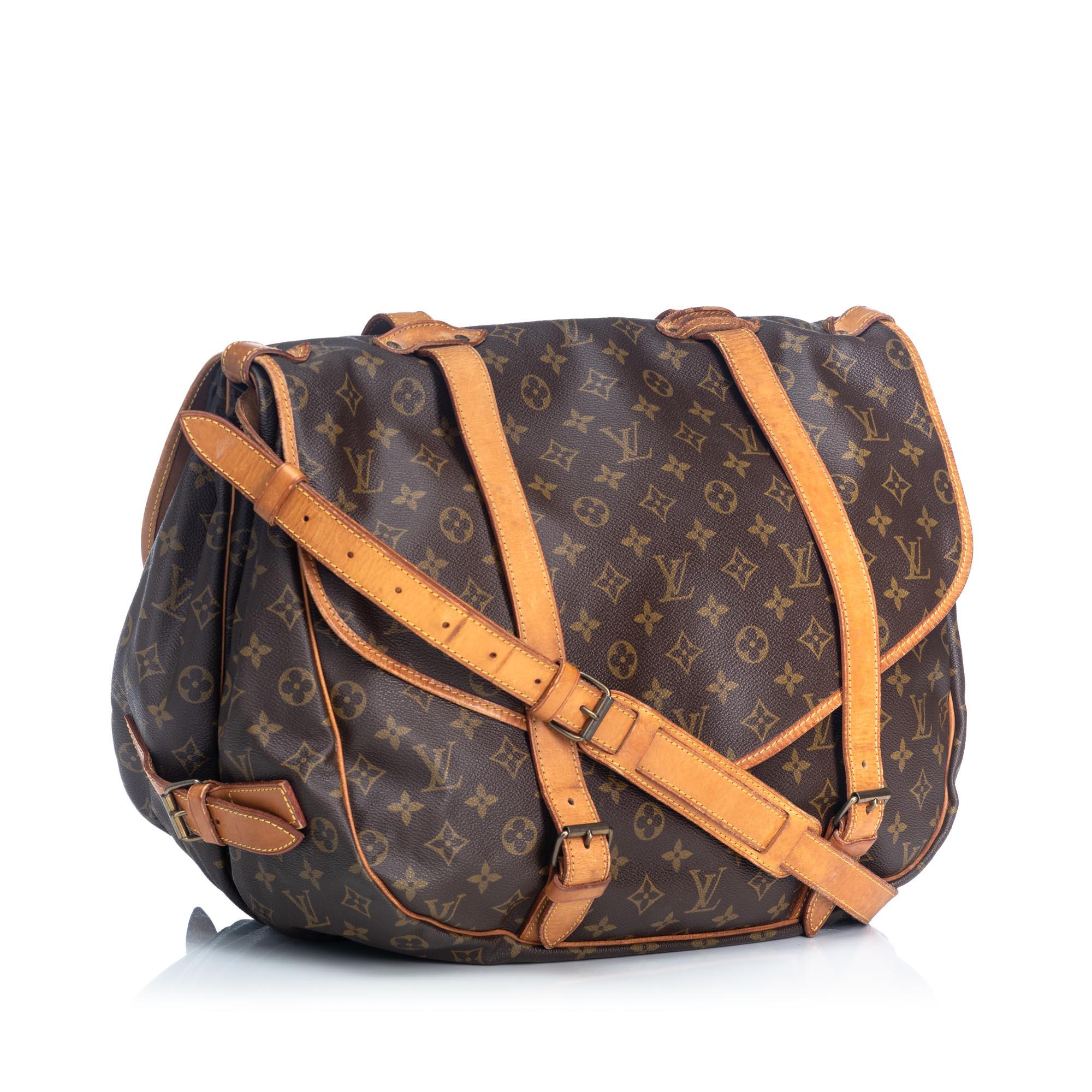 The Saumur 43 features a monogram canvas body with leather strap details, dual compartments with front flaps and belt buckle closures, and interior open compartments. It carries as B condition rating.

Inclusions: 
This item does not come with