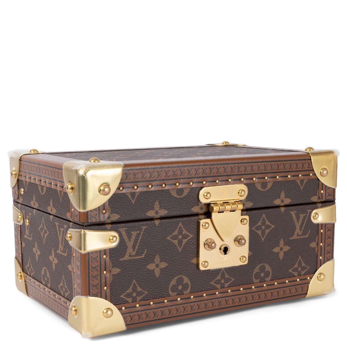 100% authentic Louis Vuitton Coffret Trésor 24 treasure case in Ebene brown Monogram canvas. Features hard shell, logo stamped leather trim with brass rivets and corner reinforcements. Closes with a brass lock on the front. Lined in Lagoon blue