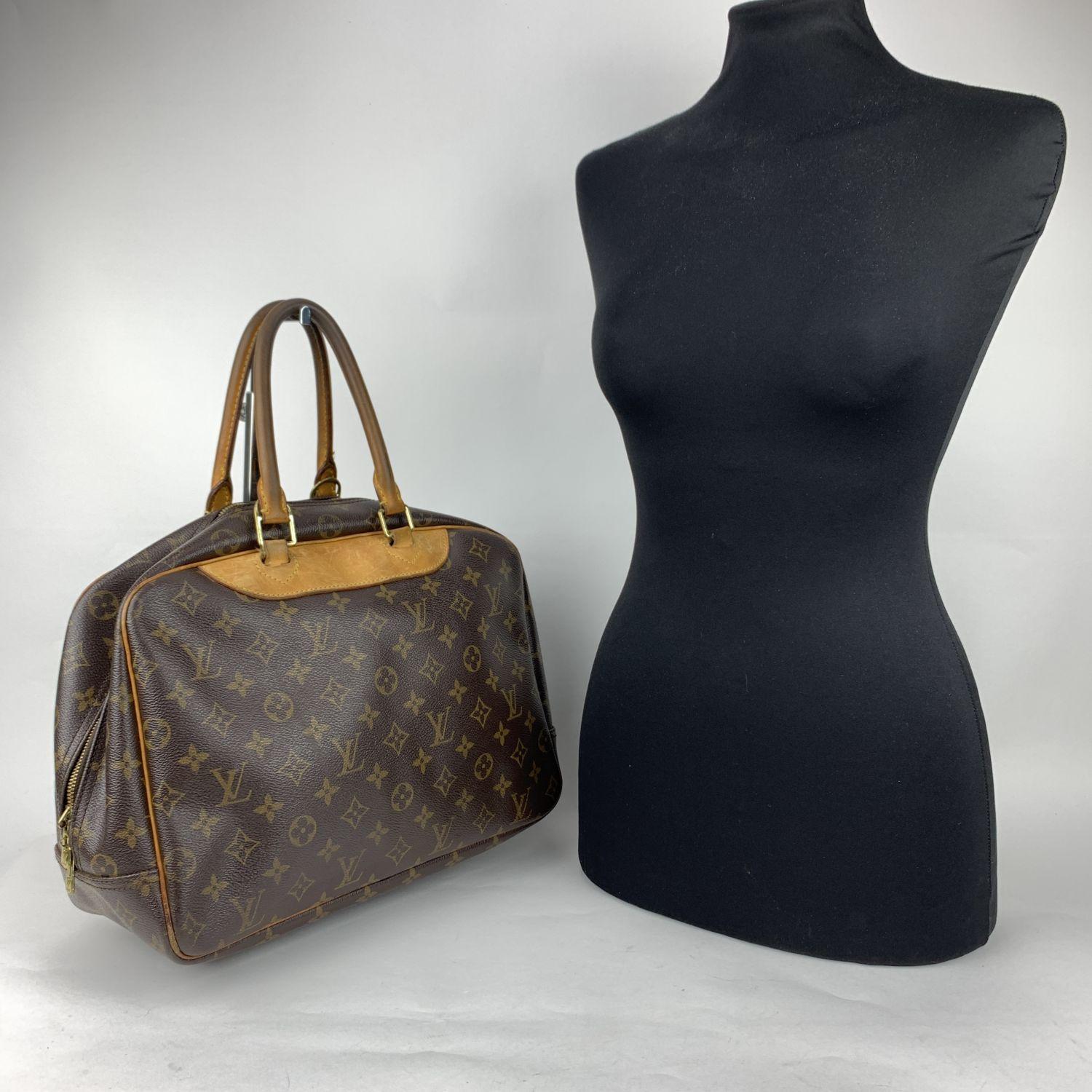 Louis Vuitton 'Deauville' satchel bag crafted in timeless monogram canvas with genuine leather trim and handles. Upper zipper closure. 1 exterior open pockets. Beige washable lining with 4 open pockets inside, 1 elastic strap to hold bottles and
