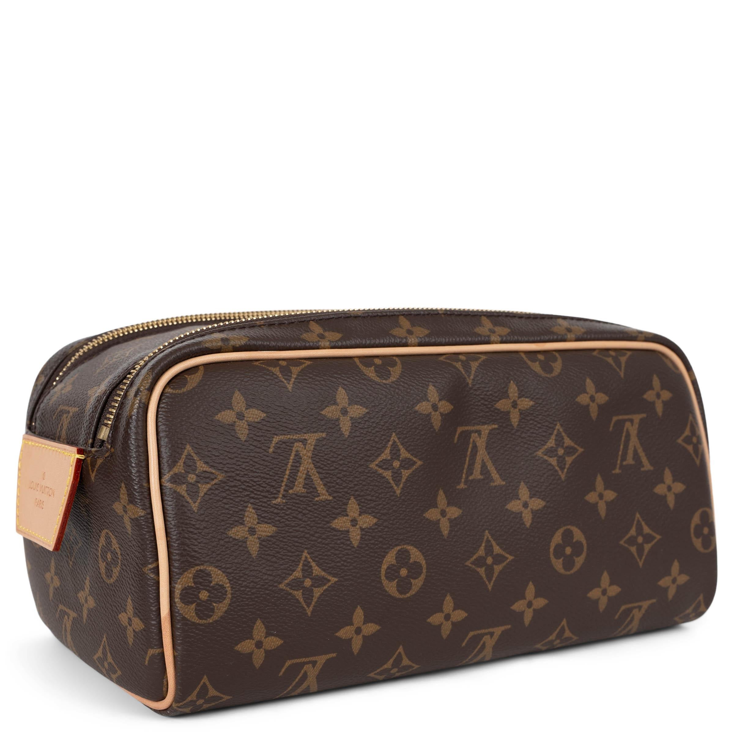 This 100% authentic Louis Vuitton Dopp Kit toiletry bag in brown Monogram canvas is a sophisticated travel essential. Featuring a structured silhouette with natural cowhide leather trims, it offers a spacious interior for toiletries and grooming
