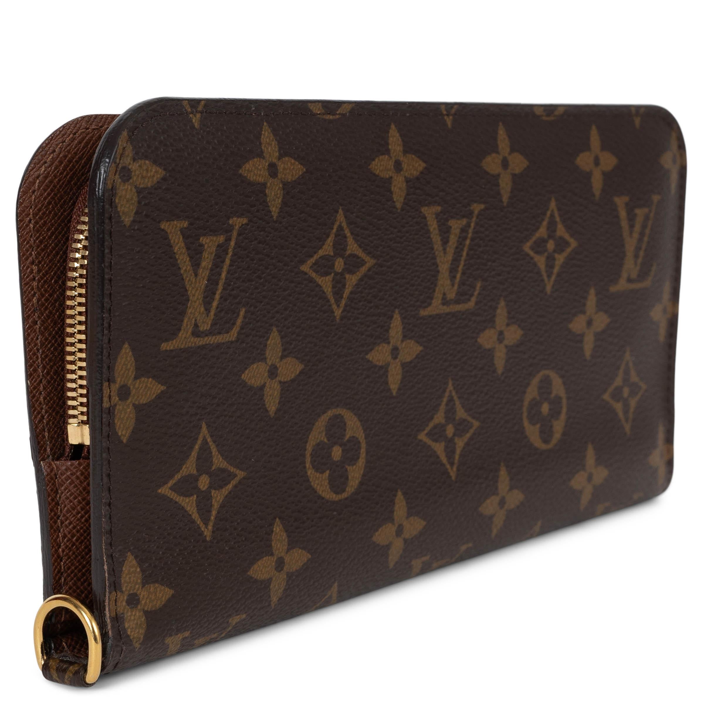 Questo portafoglio 100% autentico Louis Vuitton Insolite in classico Ebene e Monogram Canvas color oliva è un raffinato mix di eleganza e funzionalità. Accentuata da una metalleria dorata, si apre con due pulsanti per rivelare un interno foderato di