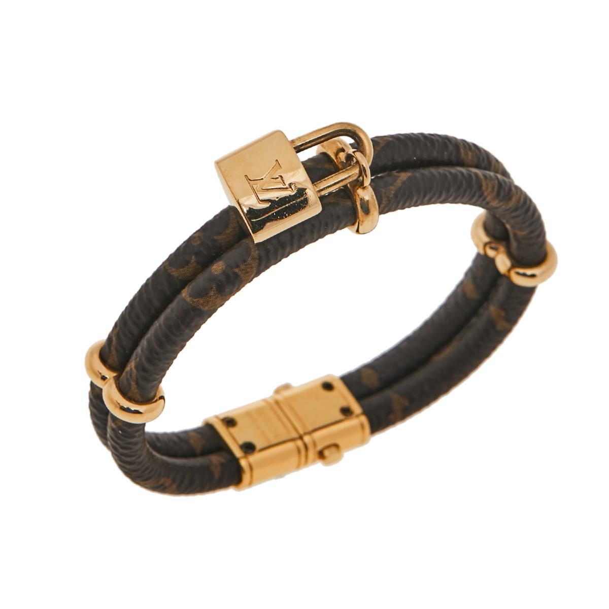 This Keep It Twice bracelet by Louis Vuitton adds a touch of luxurious charm to any ensemble. It features a gold-tone padlock inspired by vintage Louis Vuitton trunks. This lovely double bangle bracelet, crafted in monogram coated canvas, is very