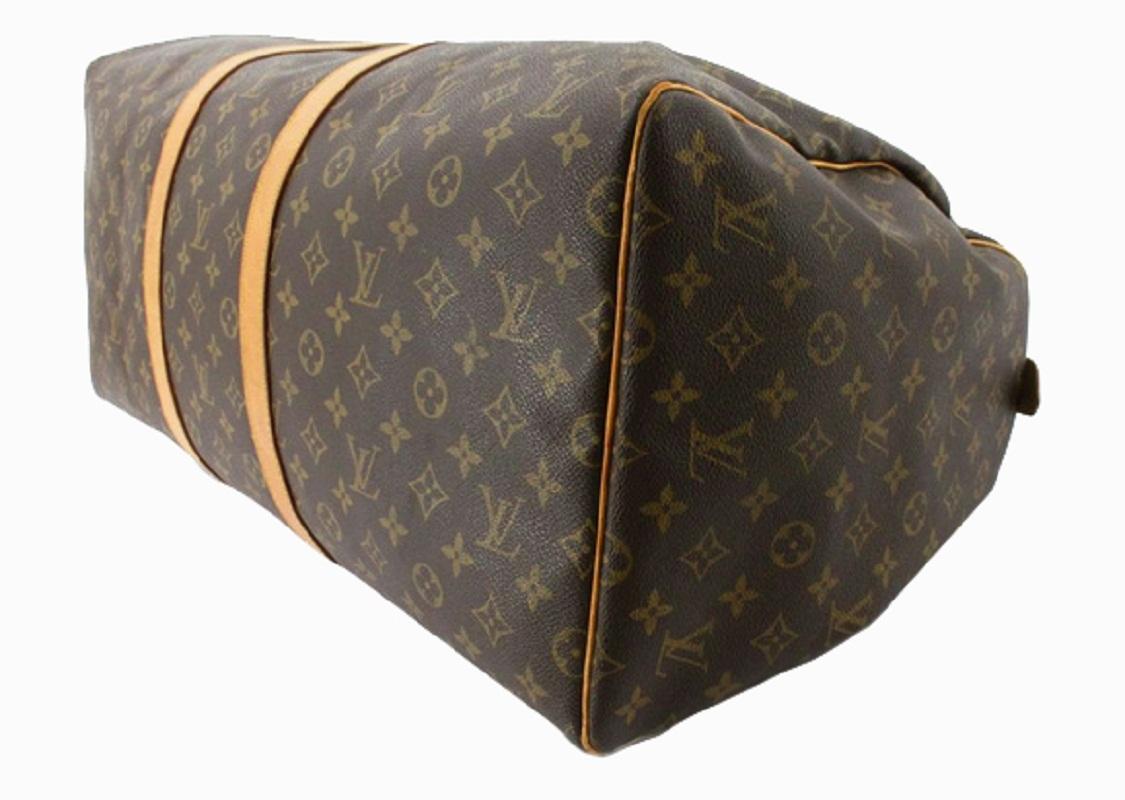 Brown and tan monogram coated canvas Louis Vuitton Keepall 55 with gold-tone hardware, tan vachetta leather trim featuring yellow contrast stitching, dual rolled top handles, luggage tag, brown canvas lining and zip closure at top.


70529MSC