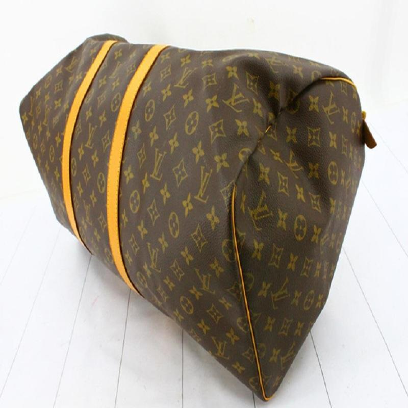 Brown and tan monogram coated canvas Louis Vuitton Keepall 55 with gold-tone hardware, tan vachetta leather trim featuring yellow contrast stitching, dual rolled top handles, brown canvas lining and zip closure at top.


72764MSC

22