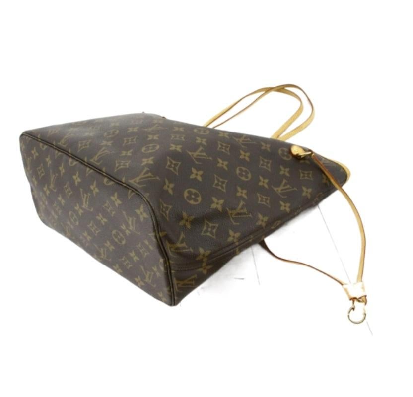 Brown and tan monogram coated canvas Louis Vuitton Neverfull MM with gold-tone hardware, tan vachetta leather trim, brown and tan printed woven interior lining, single pocket at interior wall with zip closure, clasp closure at top and drawstring