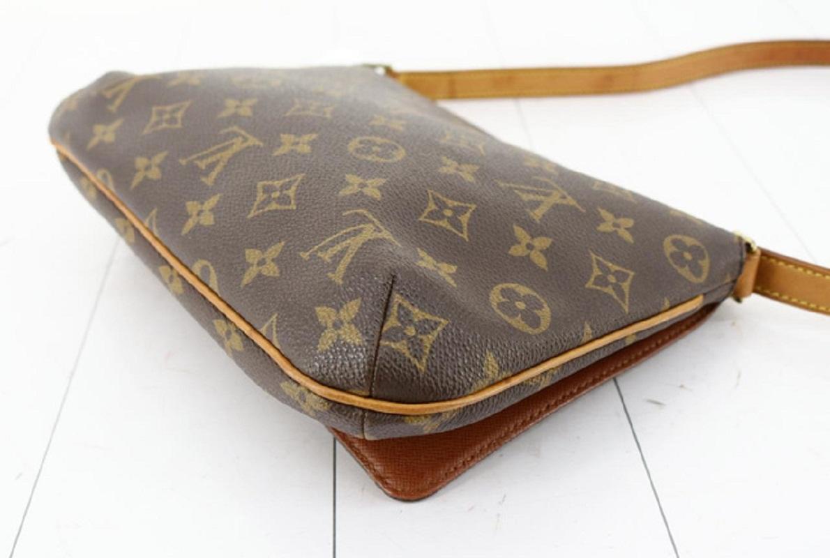 Brown and tan monogram coated canvas Louis Vuitton Musette Tango bag with gold-tone hardware, tan vachetta leather trim, single short flat shoulder strap, marigold Alcantara lining, single pocket at interior wall and magnetic snap closure at front