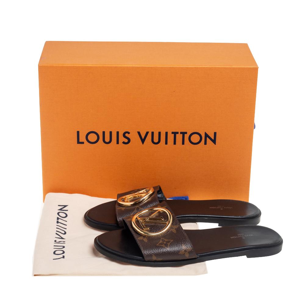Present your feet with utmost comfort by choosing these 'Lock It' flat slides from the iconic House of Louis Vuitton. They are crafted using the signature Monogram canvas and detailed with a gold-toned 'LV' accent on the vamps. These slides will