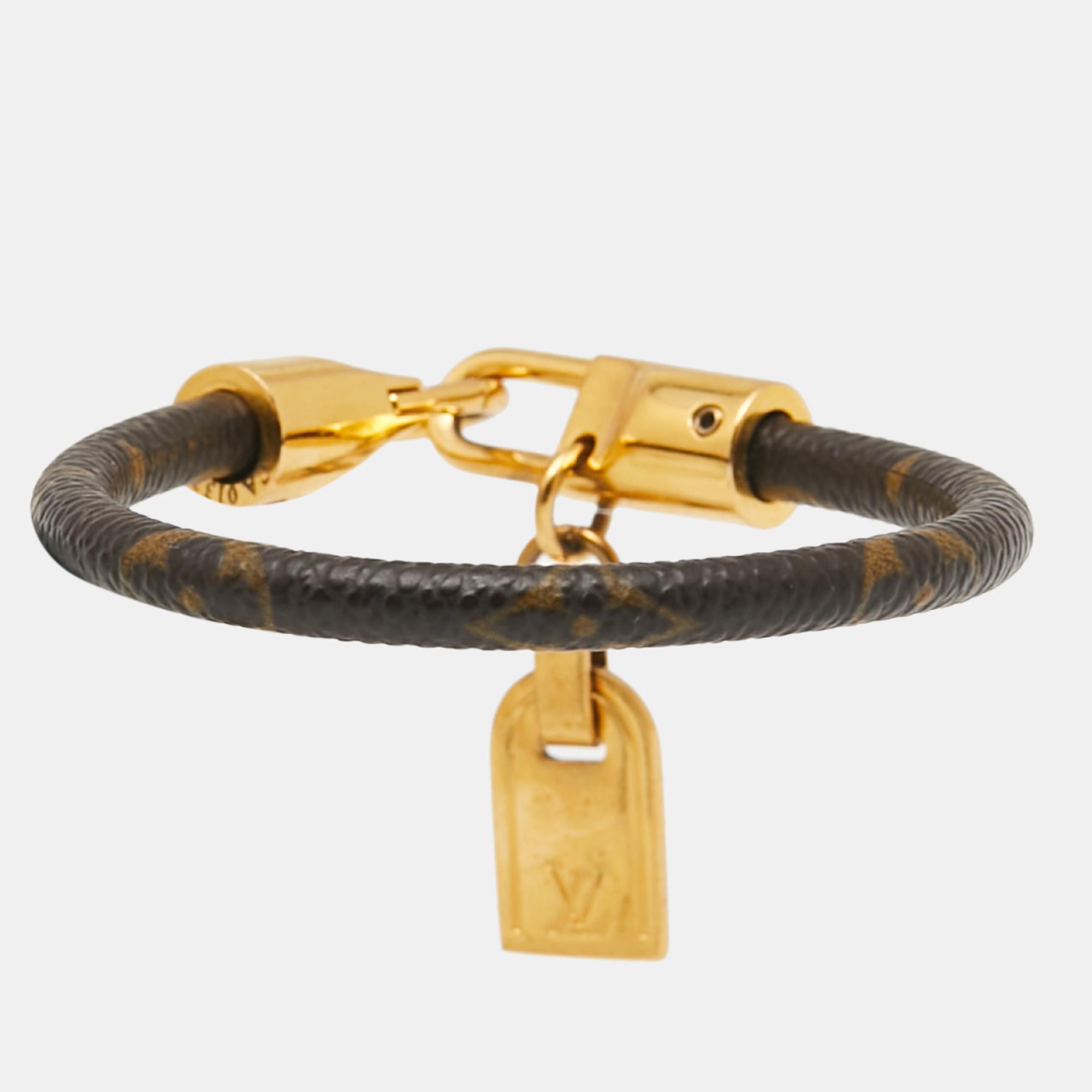 Grace your wrist with this stunner of a bracelet from Louis Vuitton. The piece is from their Luck It collection and it has been crafted from monogram canvas, enhanced with gold-tone hardware, and finished with a metal tag that carries the signature