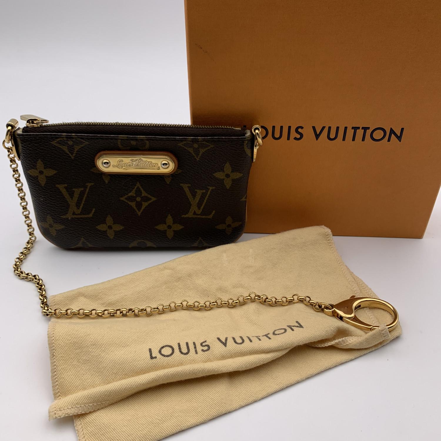 Chic Mini Pouch 'Milla' by LOUIS VUITTON in timeless Monogram canvas. Upper zipper closure. Gold metal key chain and soft microfiber lining. Can accompanies Vuitton bags, it can be used with the wristlet strap, as a wrist bag), or without the strap,