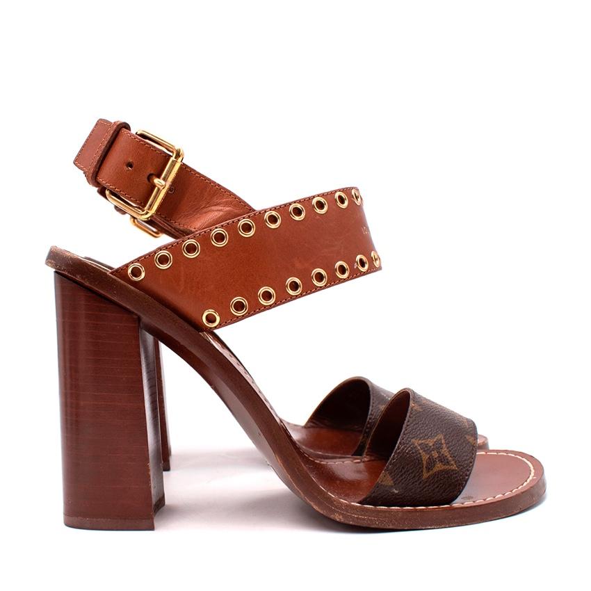  Louis Vuitton Brown Monogram Canvas Passenger Block Heeled Sandals
 

 - Fusion of smooth calf leather in warm tan and signature mongram canvas 
 - Decorative gold-tone metal eyelets punched into the foot strap which is adorned with the house