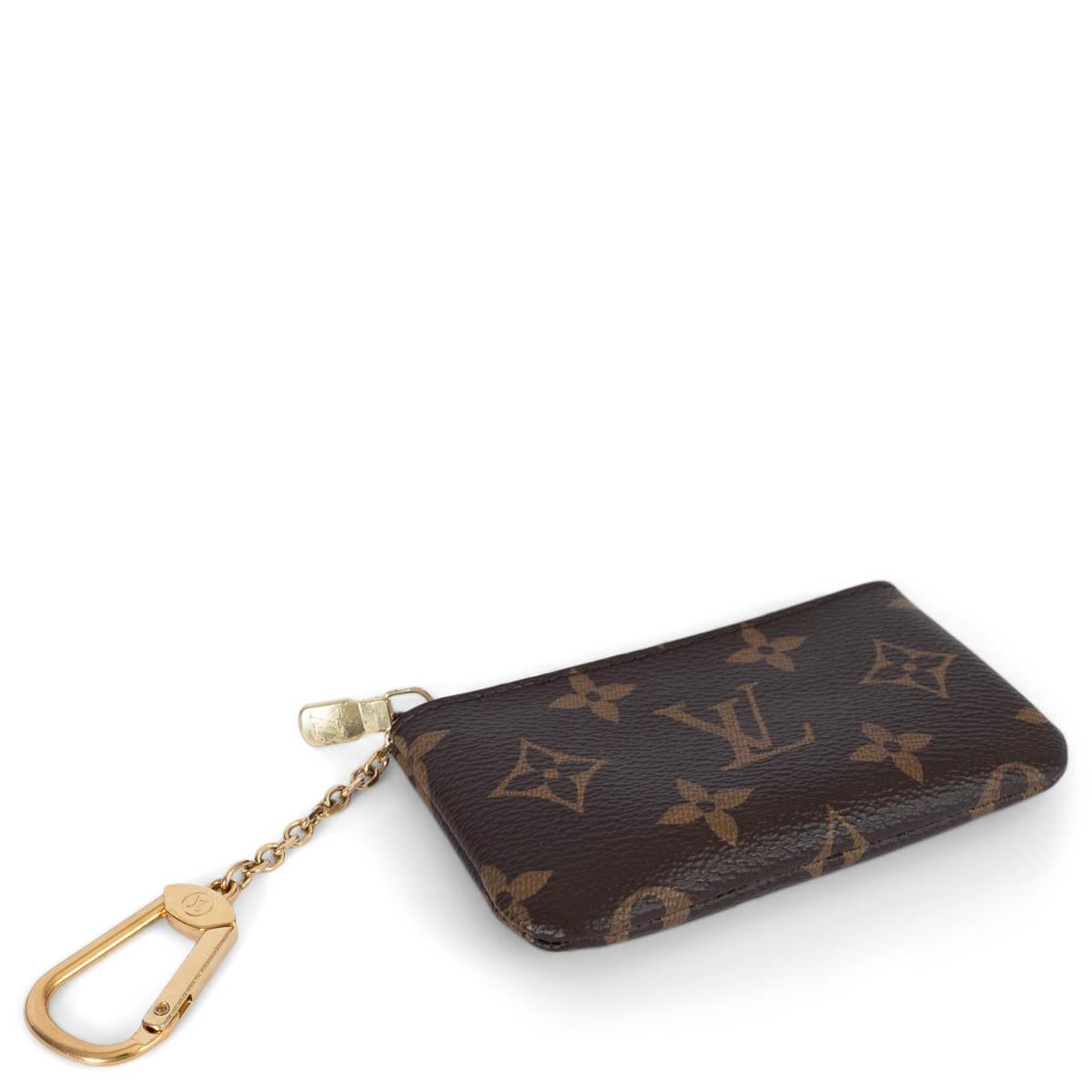 100% authentic Louis Vuitton key case in rown Monogram canvas. The design offers space for coins, cards, folded banknotes and other small items. It features an LV engraved zipper and attaches to the D-ring inside most Louis Vuitton handbags. It can