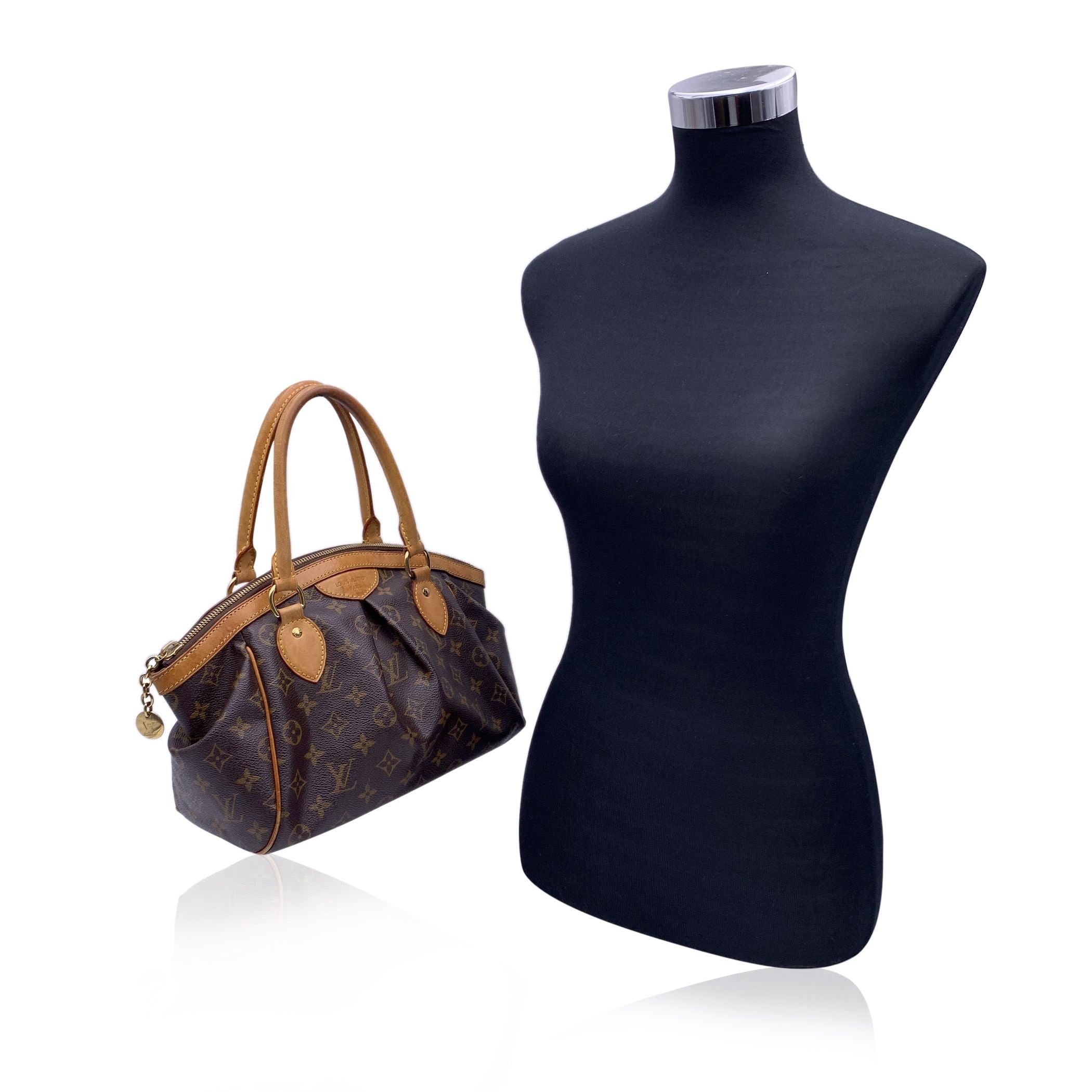 Louis Vuitton Monogram Canvas Tivoli PM Bag. Le Tivoli, dont le nom est inspiré de la célèbre ville de Tivoli, en Italie, présente des détails élégants tels qu'un plissé inversé et un cadre supérieur incurvé. Toile Monogram avec garniture en cuir de