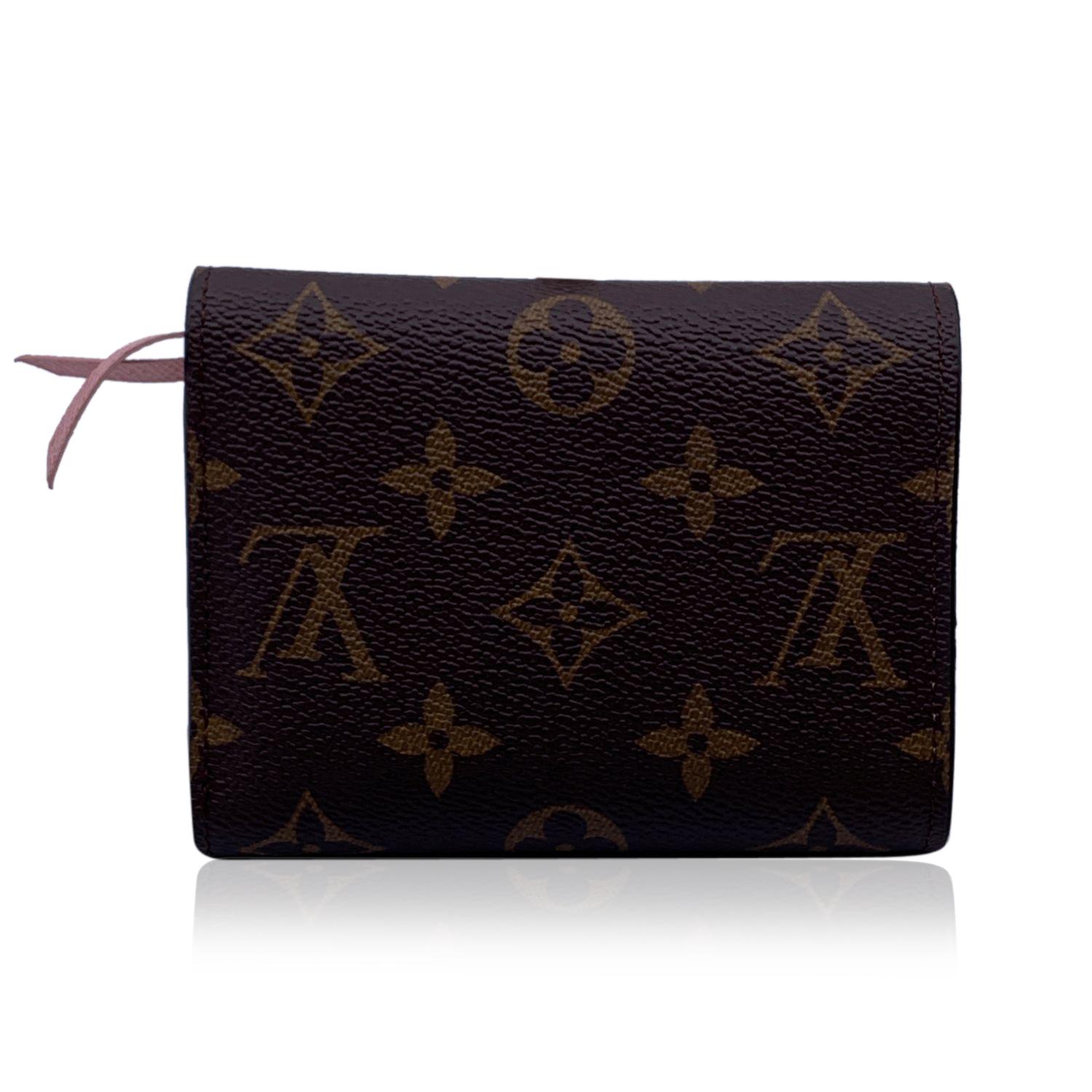 Louis Vuitton Monogram Canvas Victorine Wallet. Monogram canvas exterior and pink genuine leather interior. Snap closure.1 zip coin section, 1 bill compartment, 2 open pockets and 6 credit card slots. 'LOUIS VUITTON Paris - Made in France' embossed