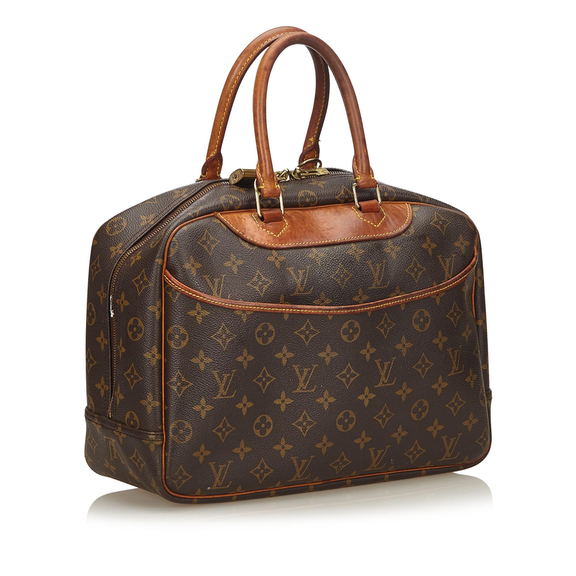 The Deauville features a monogram canvas body, rolled leather handles, an exterior slip pocket, a top zip closure, and interior open pockets. It carries as B condition rating.

Inclusions: 
Padlock


Louis Vuitton pieces do not come with an