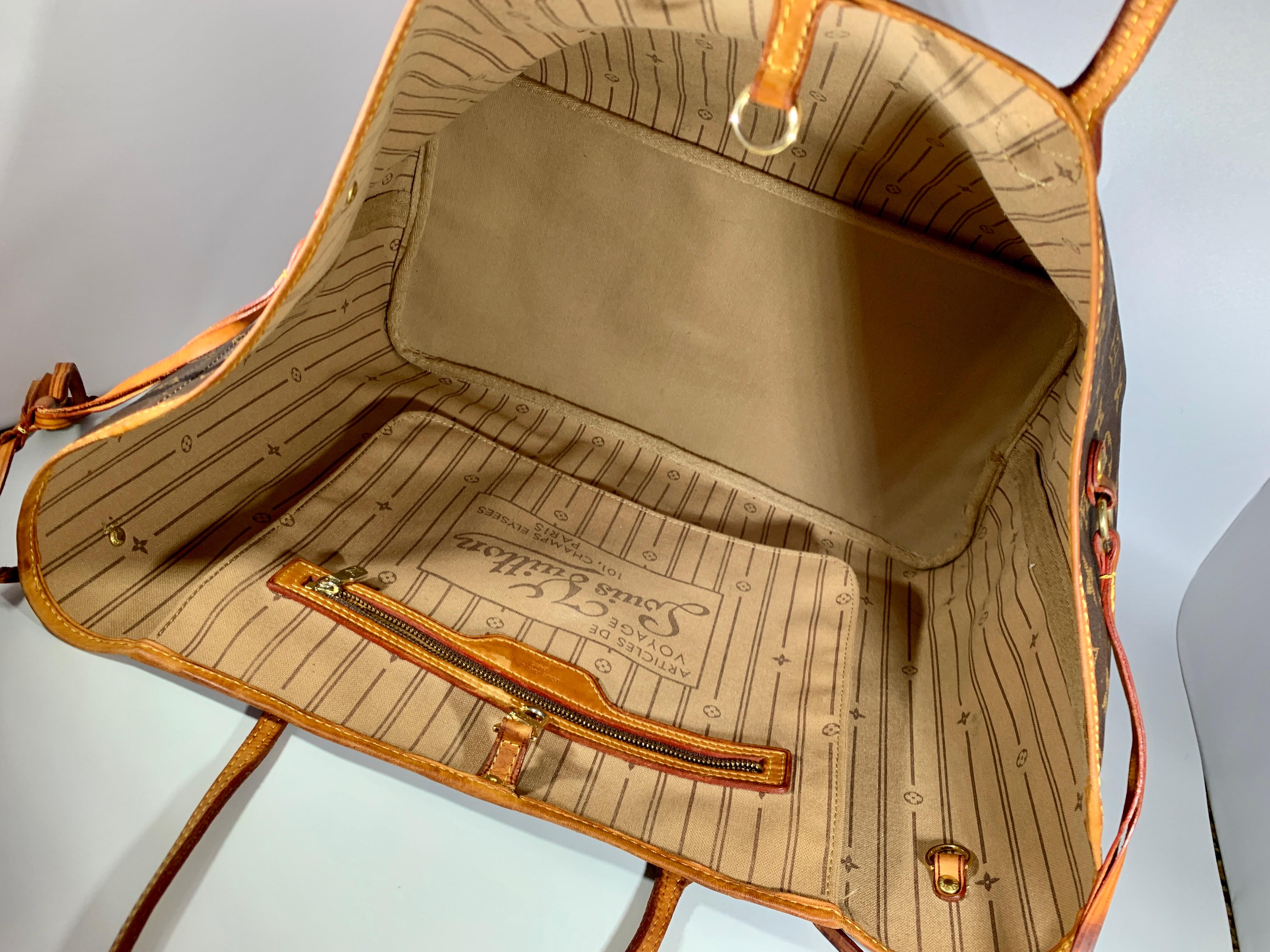 
Brown and tan monogram coated canvas Louis Vuitton Neverfull MM with brass hardware, dual flat shoulder straps, tan Vachetta leather trim, drawstring accents at sides, tonal striped canvas lining, single zip pocket at interior wall and clasp