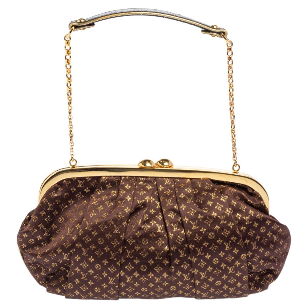 This stunning limited edition Aumoniere bag hails from the house of Louis Vuitton. It has been meticulously crafted from monogram satin and carries a lovely shade of brown. It has a gold-tone frame, a chain-link, and a lock closure that opens to a