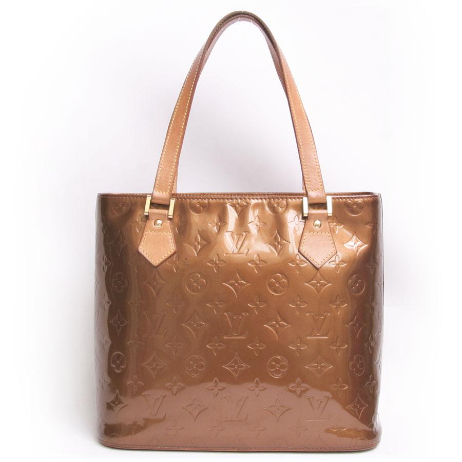This LOUIS VUITTON bag is in shiny brown patent monogram leather with brown stitching. The two handles are in brown leather with a yellow stitching (specific to Vuitton). The jewelry is in golden brass. The zip closure is on the top of the bag.
The