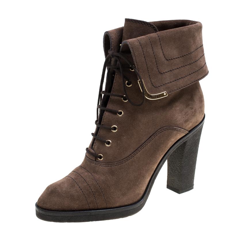 It's time to rock all your outings with these elegant ankle boots from Louis Vuitton. Modern in design and craftsmanship, these brown boots are crafted from suede with gold-tone label accents on the top folds. They are complete with laces, leather