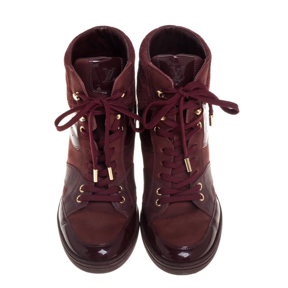 Crafted from patent leather and monogram suede, this Louis Vuitton pair has a front lace-up closure complemented with gold-tone hardware. The boots are set on 6 cm high concealed wedges and rubber soles. Designed with skill, they offer great