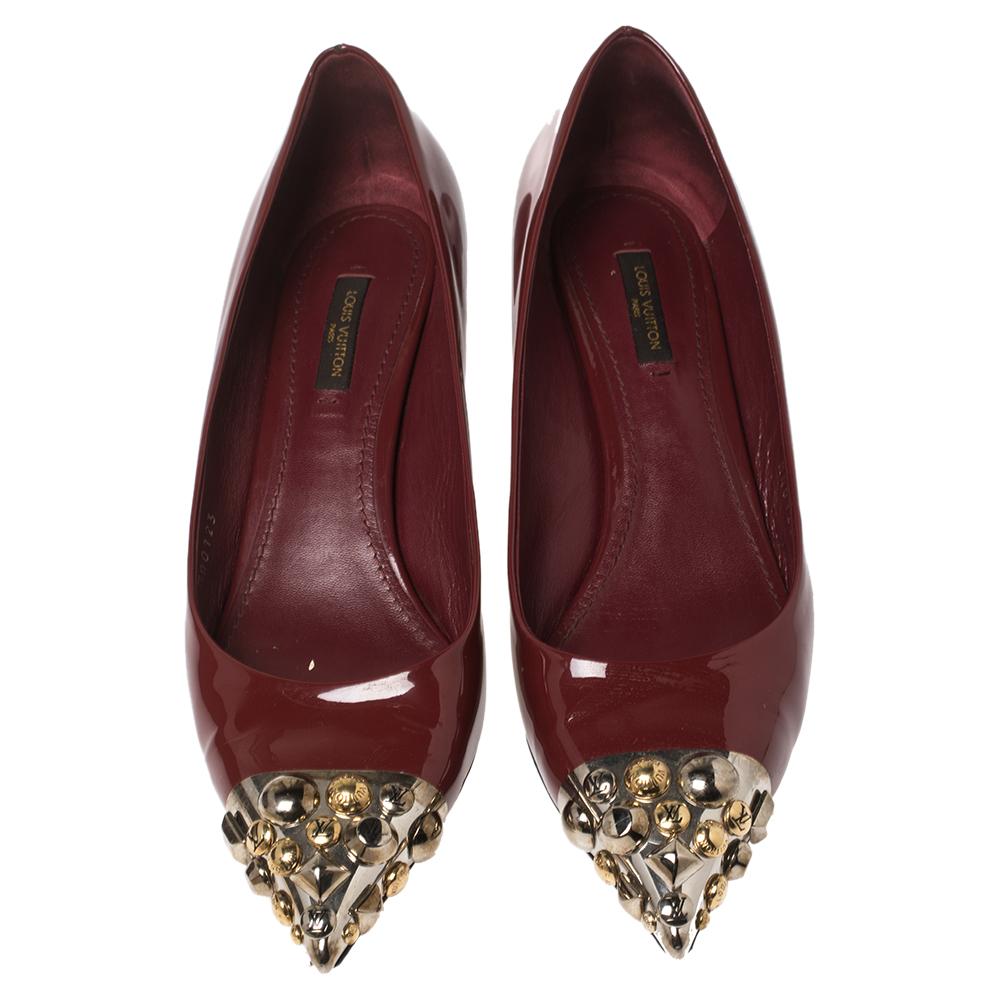 Grand in burgundy patent leather, these pointed-toe pumps from Louis Vuitton are designed with studded pointed toes, comfortable insoles, and kitten heels. They'll complement your formals as well as casuals.

Includes: Original Dustbag, Original