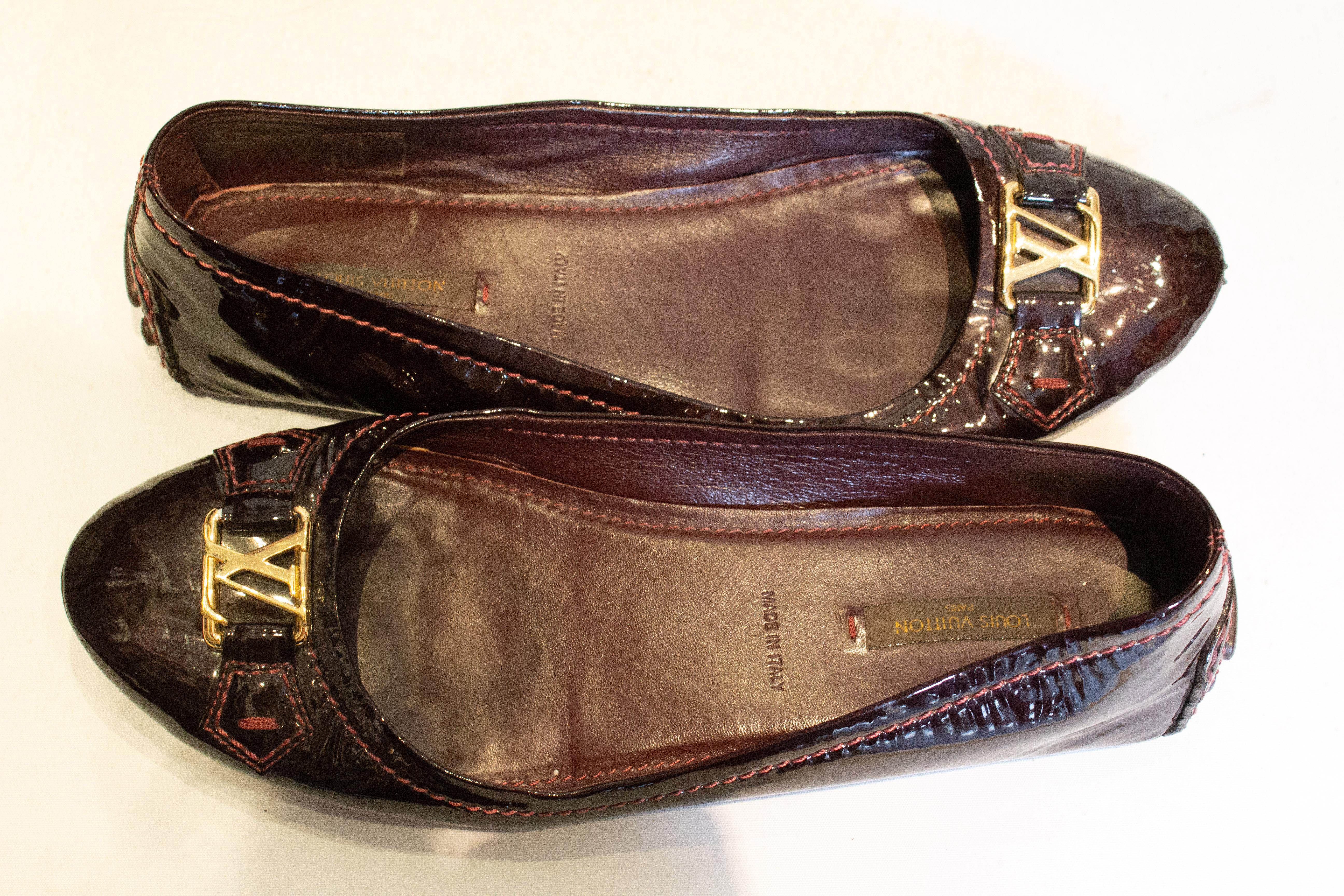 A great pair of pumps by  Louis Vuitton. The shoes are in a burgundgy colour patent leather with 'gold LV detail on the front. They are marked size 39, style FA1100.