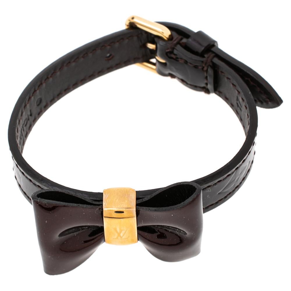 Add a touch of feminine style to your look with this Favorite bracelet from Louis Vuitton. This bracelet is made with burgundy monogram Vernis leather and gold-tone hardware. It features a bow detail at the front and buckle closure. A classy piece
