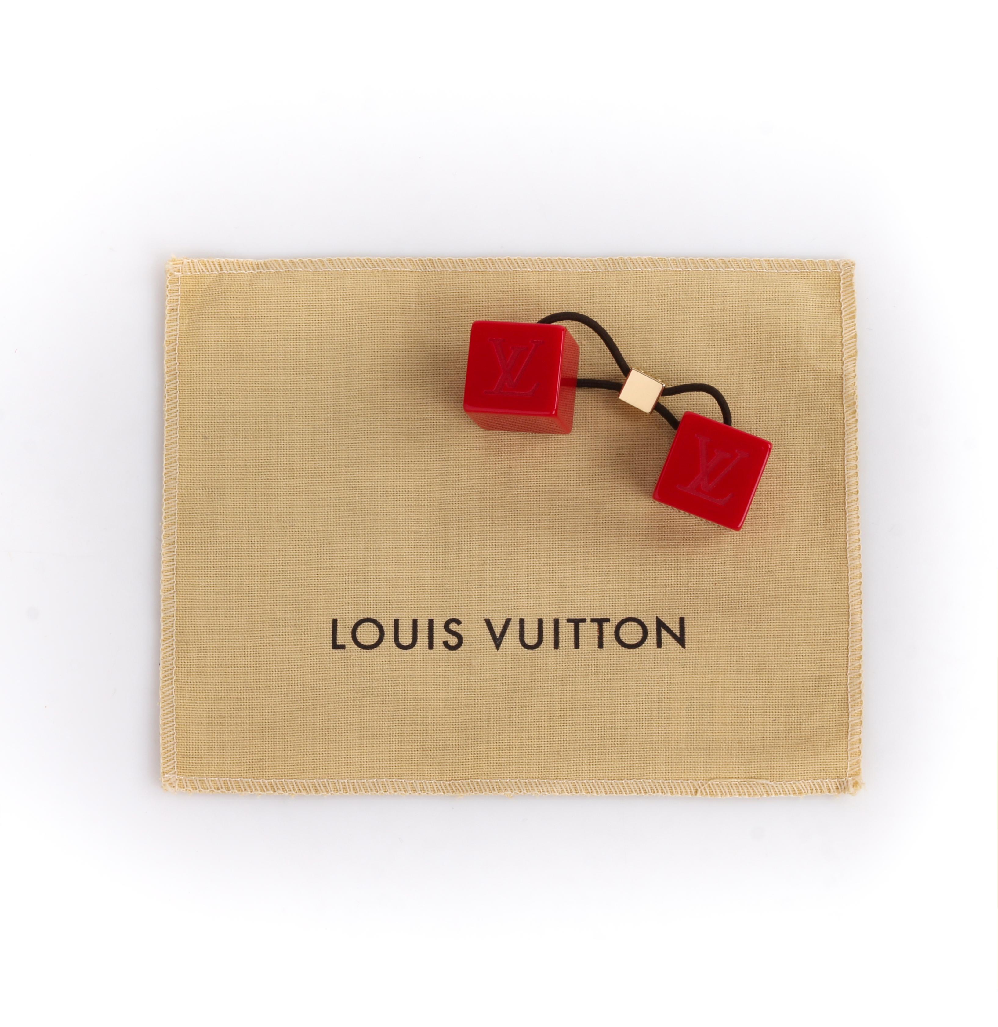 LOUIS VUITTON Burnt Red Elastic Gold LV Hair Cubes 
 
Estimated Retail: $400
 
Brand / Manufacturer: Louis Vuitton 
Style: Hair cube, pony tail holder, hair tie
Color(s): Shades of red, brown and gold.
Unmarked Material: resin and elastic