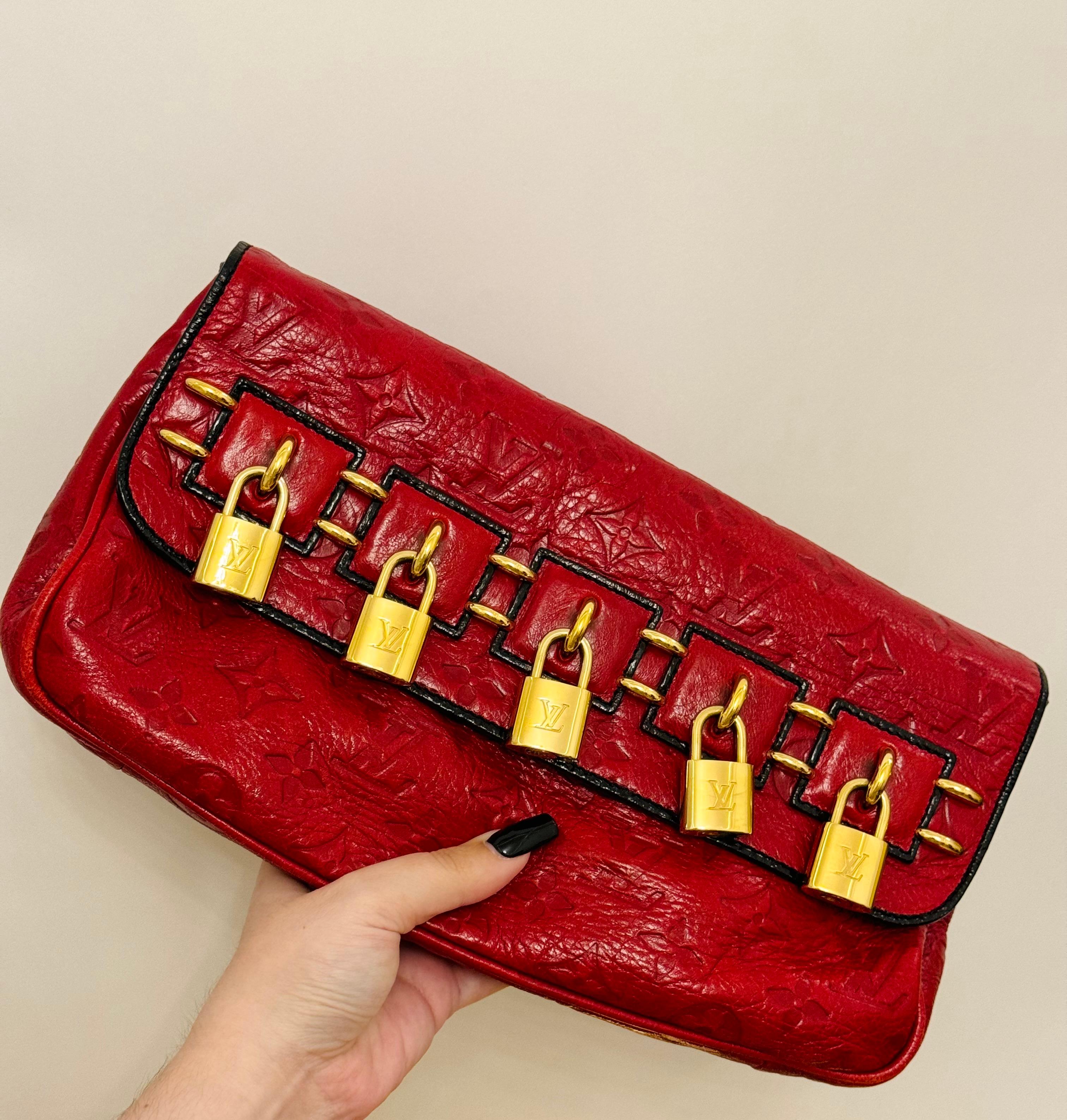 Rare Louis Vuitton by Marc Jacobs Fall Winter 2009 red glossy leather Empreinte my Deer Enigme clutch, monogram logomania, gold LV logo padlock, some minor wear, about 12 inches x 6 inches. 
