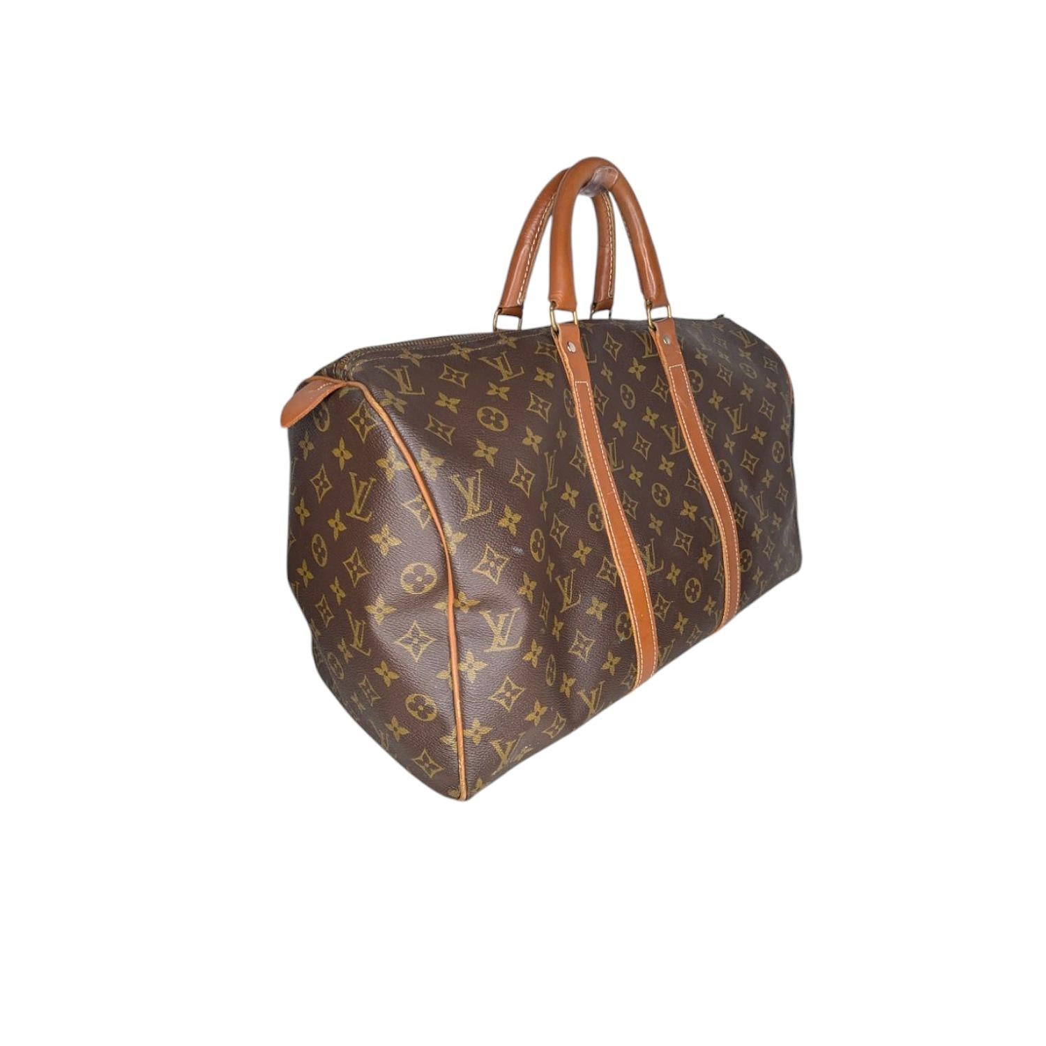From the mid 1970's to early 1990's, Louis Vuitton partnered with a US luggage company to create French Company Louis Vuitton bags. This vintage Duffel Bag in brown coated canvas with the iconic LV logo monogram pattern and brass hardware. It