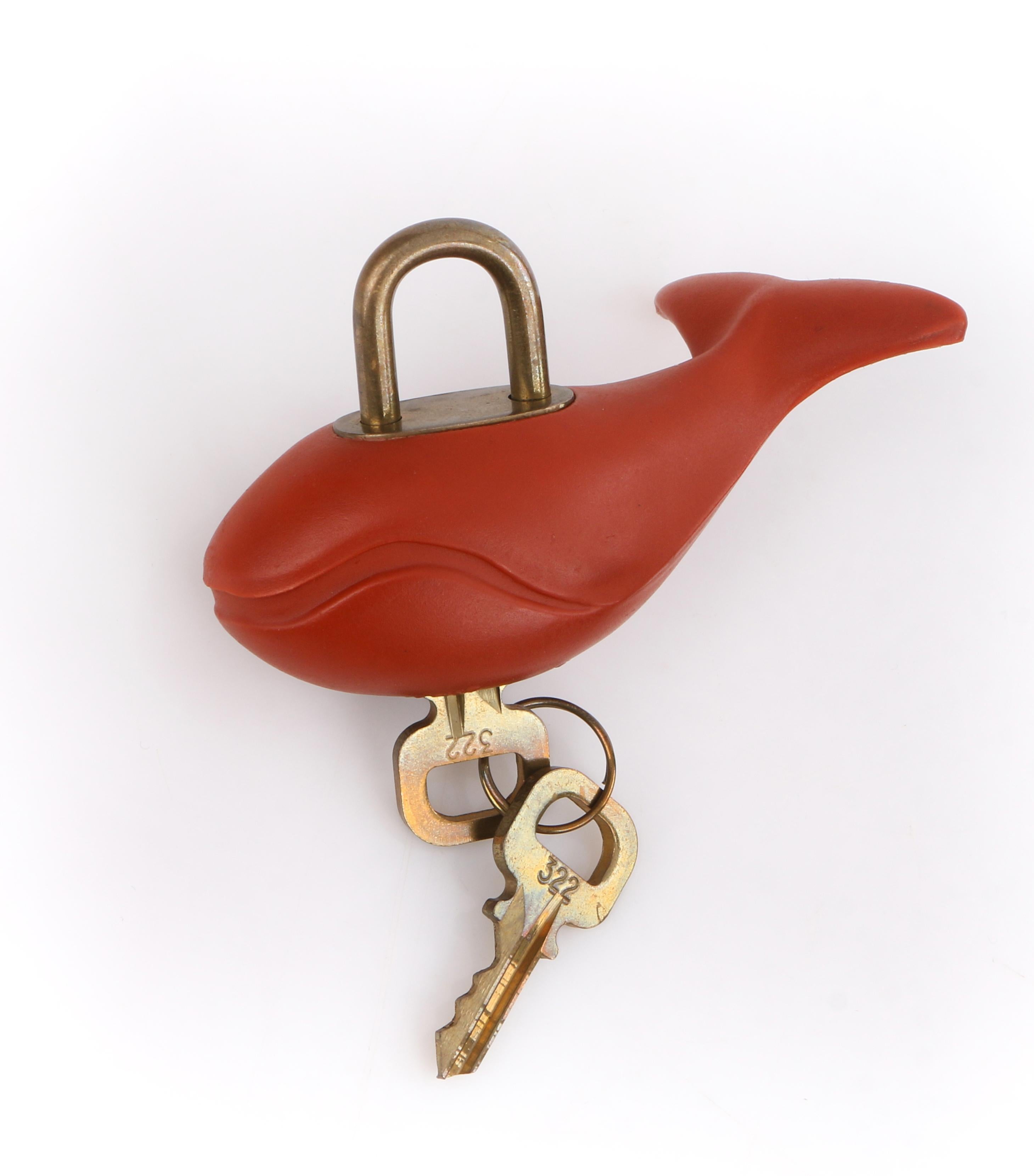 Louis Vuitton c.1995 America’s Cup Red Whale Motif Lock Keys Ltd Ed
 
Circa: 1995
Brand / Manufacturer: Louis Vuitton 
Collection: America’s Cup
Style: Lock and keys
Color(s): Shades of red and gold.
Unmarked Material: Rubber
Additional Details /