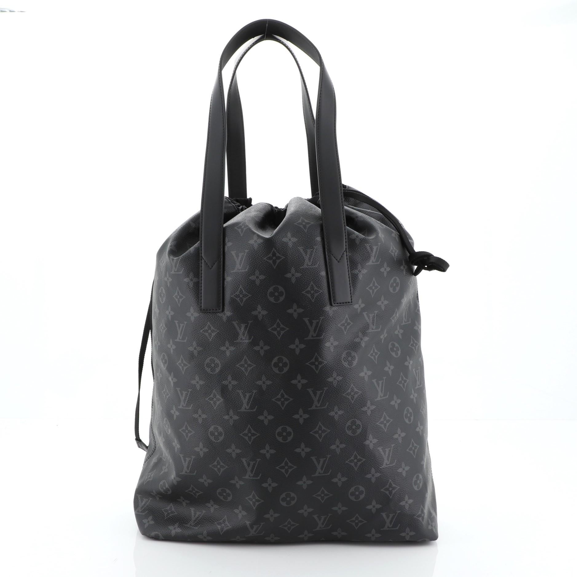 This Louis Vuitton Cabas Light Drawstring Bag Monogram Eclipse Canvas, crafted in black monogram eclipse coated canvas, features dual flat leather handles and silver-tone hardware. Its drawstring closure opens to a black nylon interior. Authenticity