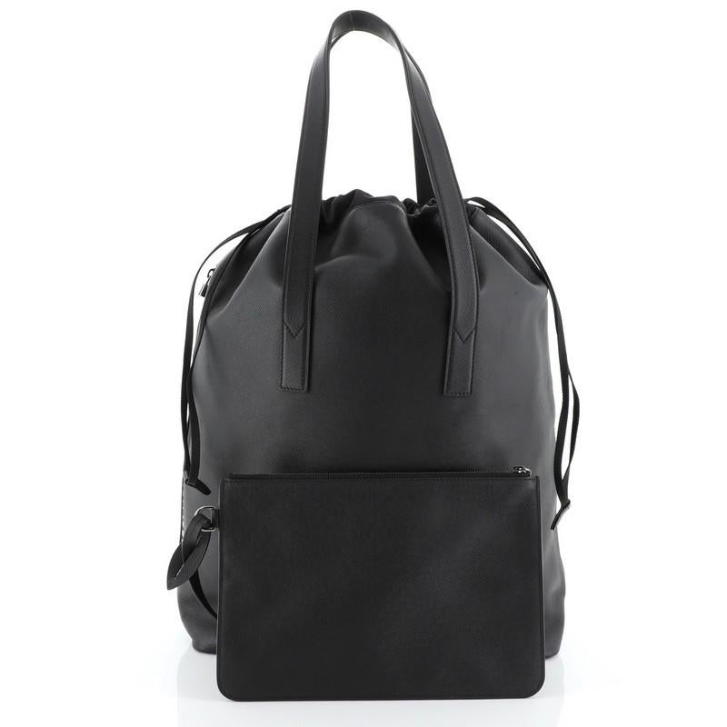 This Louis Vuitton Cabas Light Drawstring Bag Taiga Leather, crafted in black Taiga leather, features dual flat leather handles and gunmetal-tone hardware. Its drawstring closure opens to a black fabric interior. Authenticity code reads: FO5117.