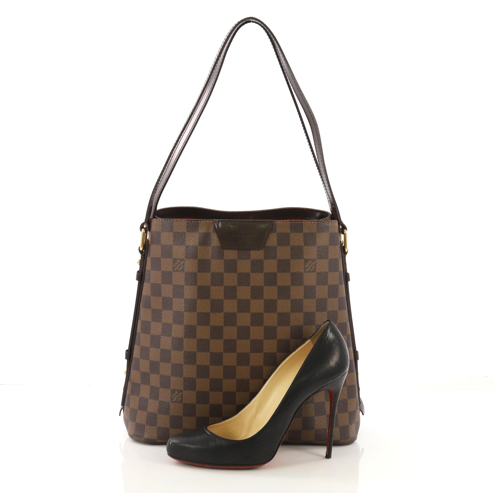 This Louis Vuitton Cabas Rivington Damier, Crafted from damier ebene coated canvas, features dual flat leather handles, two side zippers to expand, and gold-tone hardware. Its clasp hook closure opens to a red fabric interior with zip pocket.