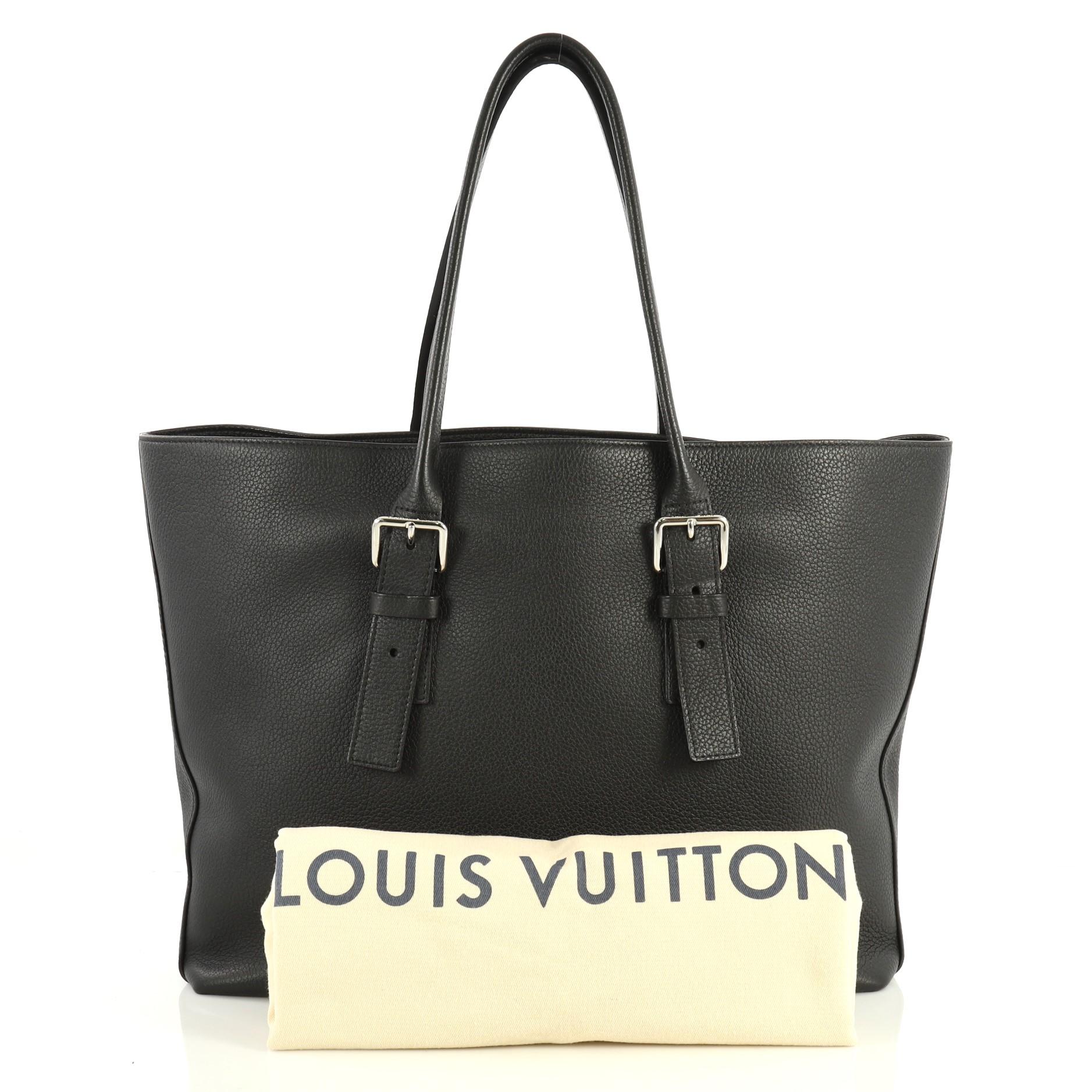 This Louis Vuitton Cabas Voyage Taurillon Leather, crafted in black taurillon leather, features dual rolled leather handles with buckle detailing and silver-tone hardware. Its wide open top showcases a black microfiber and leather interior with side