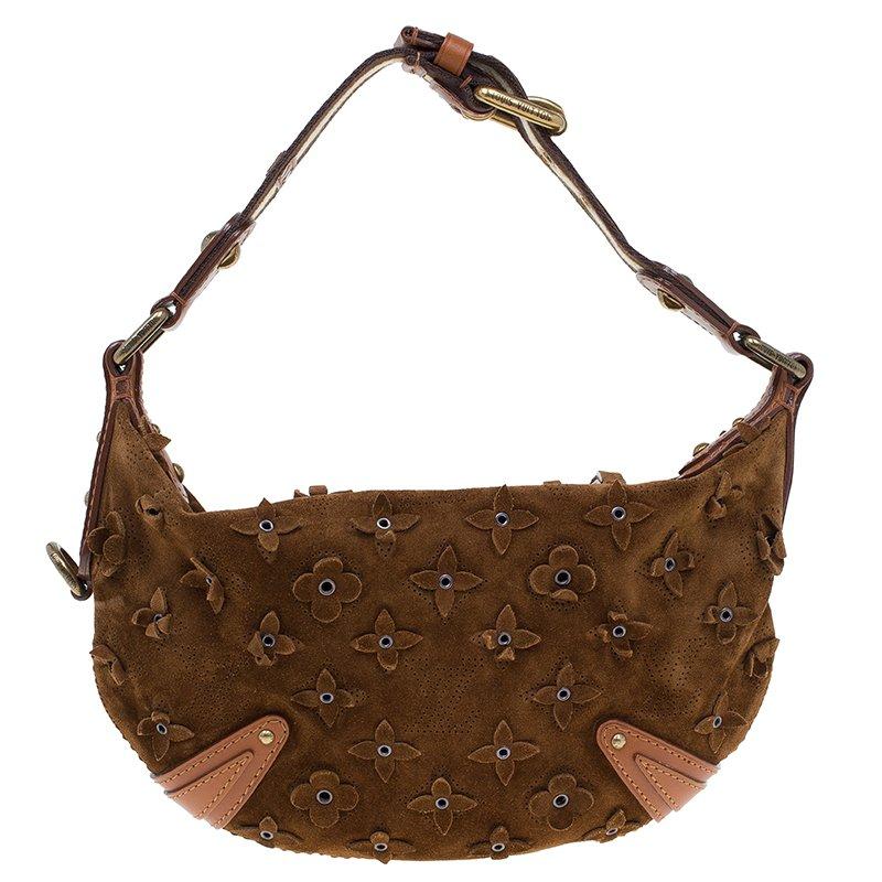 You wouldn’t want to miss this magnificent and eccentric bag by Louis Vuitton to flaunt with your casuals. Crafted from cacao suede, it features a single top handle with buckle fastenings. This bag is adorned with flowery eyelets and is accentuated