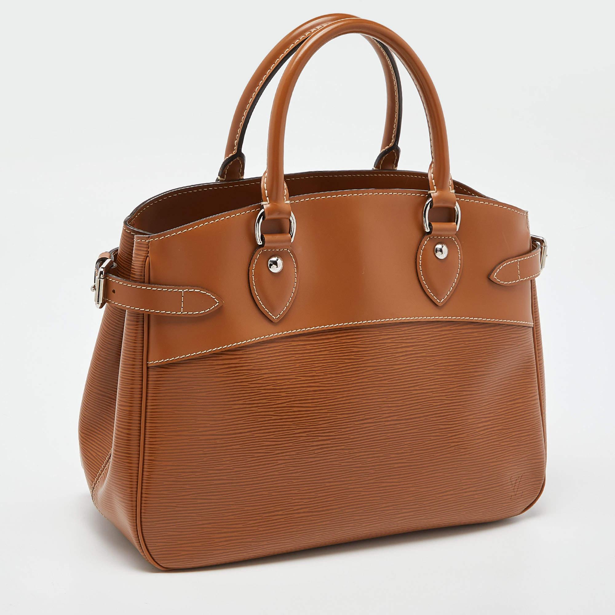 Accent a work outfit with this Louis Vuitton Passy bag. It is made from LV's signature Epi leather and features side buckle detailing, rolled leather handles, and a classy structure. The bag comes with a fabric-lined interior.

