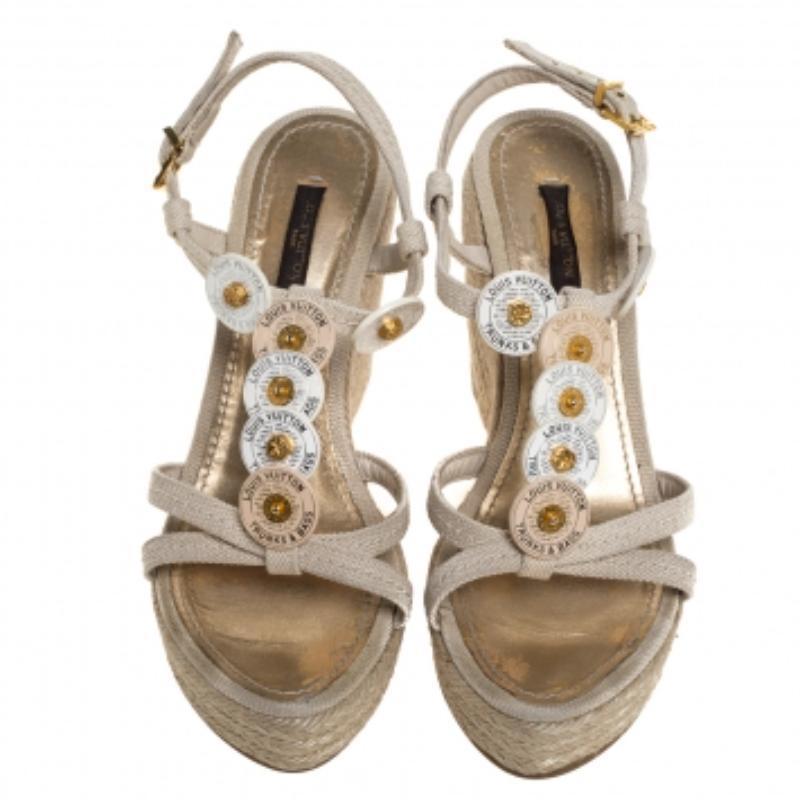Walk with comfort in these lovely sandals from Louis Vuitton! The sandals have been crafted from canvas and styled with medallion details on the vamps. They flaunt ankle closure and espadrille platform wedge heels.